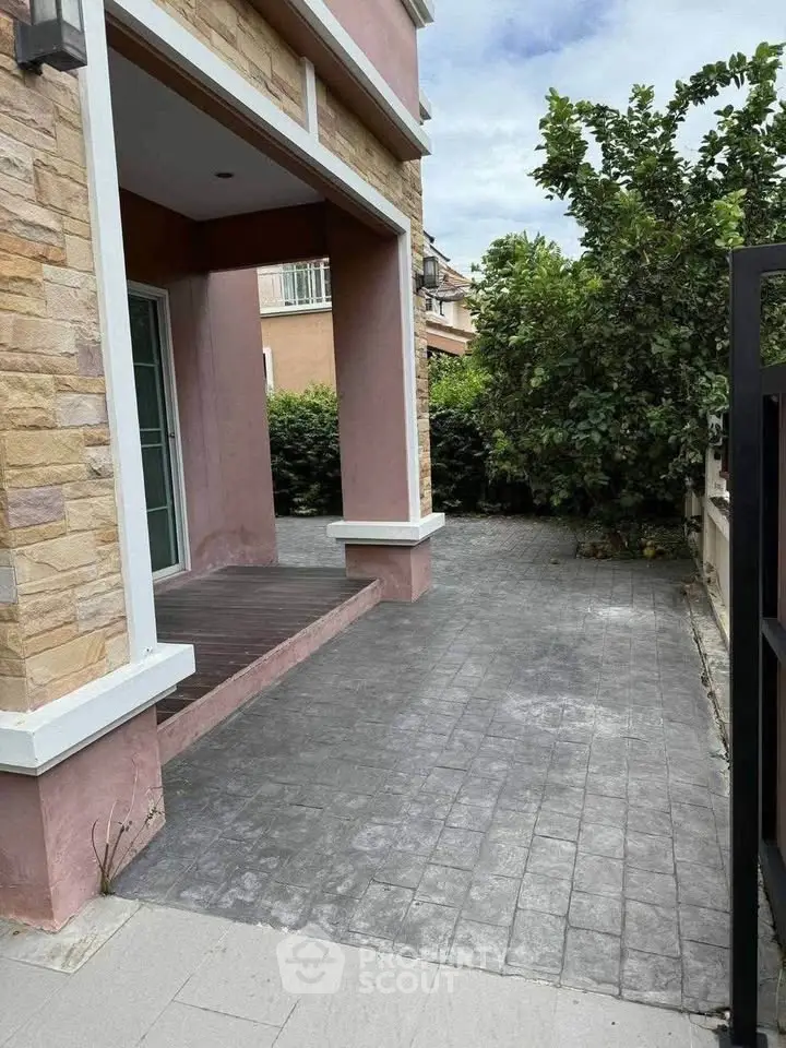 Charming exterior view of a modern home with stone accents and lush greenery.