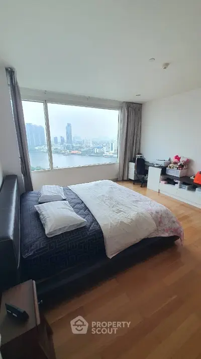 Spacious bedroom with stunning city view and modern furnishings.