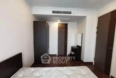 Spacious bedroom with modern furniture and wooden flooring in a stylish apartment.