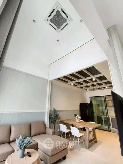 Modern living room with high ceiling and stylish furniture in a contemporary apartment.