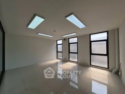 Spacious modern room with large windows and sleek lighting, perfect for office or studio use.