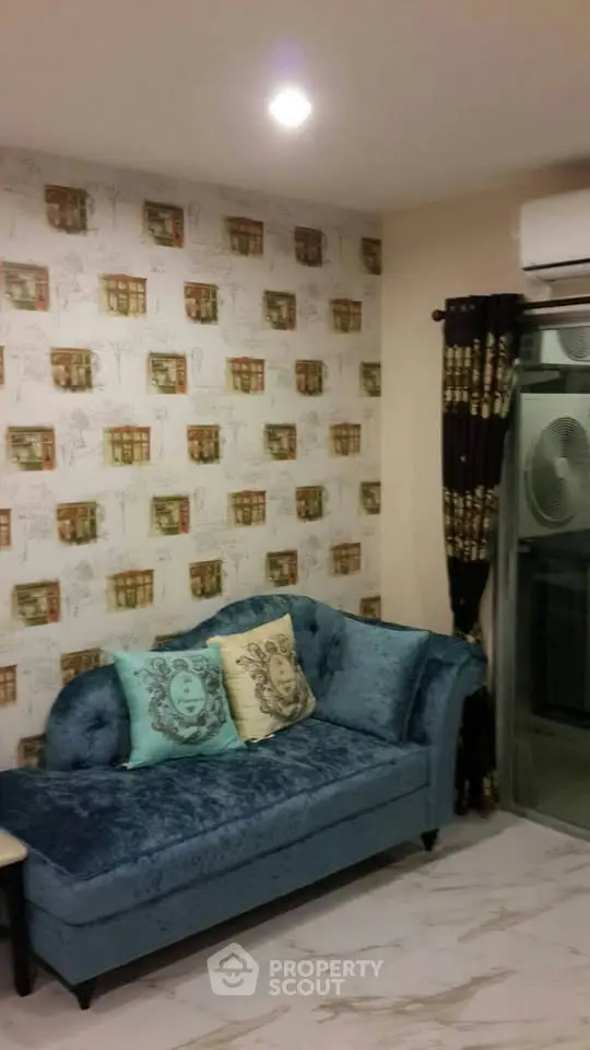 Charming living room with elegant blue sofa and stylish wallpaper, perfect for cozy relaxation.