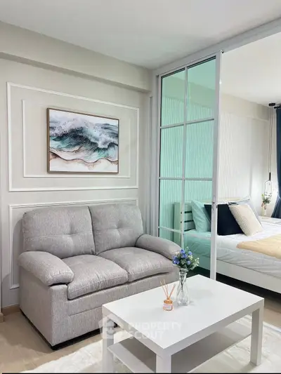 Modern living room with cozy sofa and stylish decor adjacent to a bright bedroom.