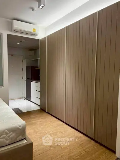 Modern bedroom with sleek wooden flooring and built-in wardrobe