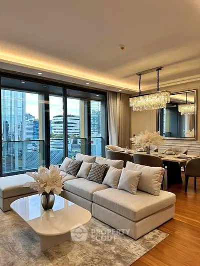 Luxurious living room with elegant decor and city view, featuring plush seating and modern lighting.
