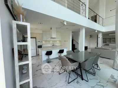 Luxurious open-plan living room with modern kitchen and elegant dining area in a stylish apartment.