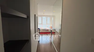 Modern bedroom with large window and wooden flooring, featuring a cozy bed and stylish decor.