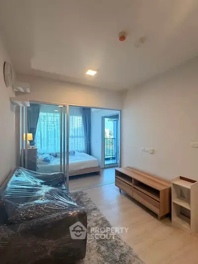 Modern apartment interior with cozy living room and bedroom, featuring stylish furniture and natural light.