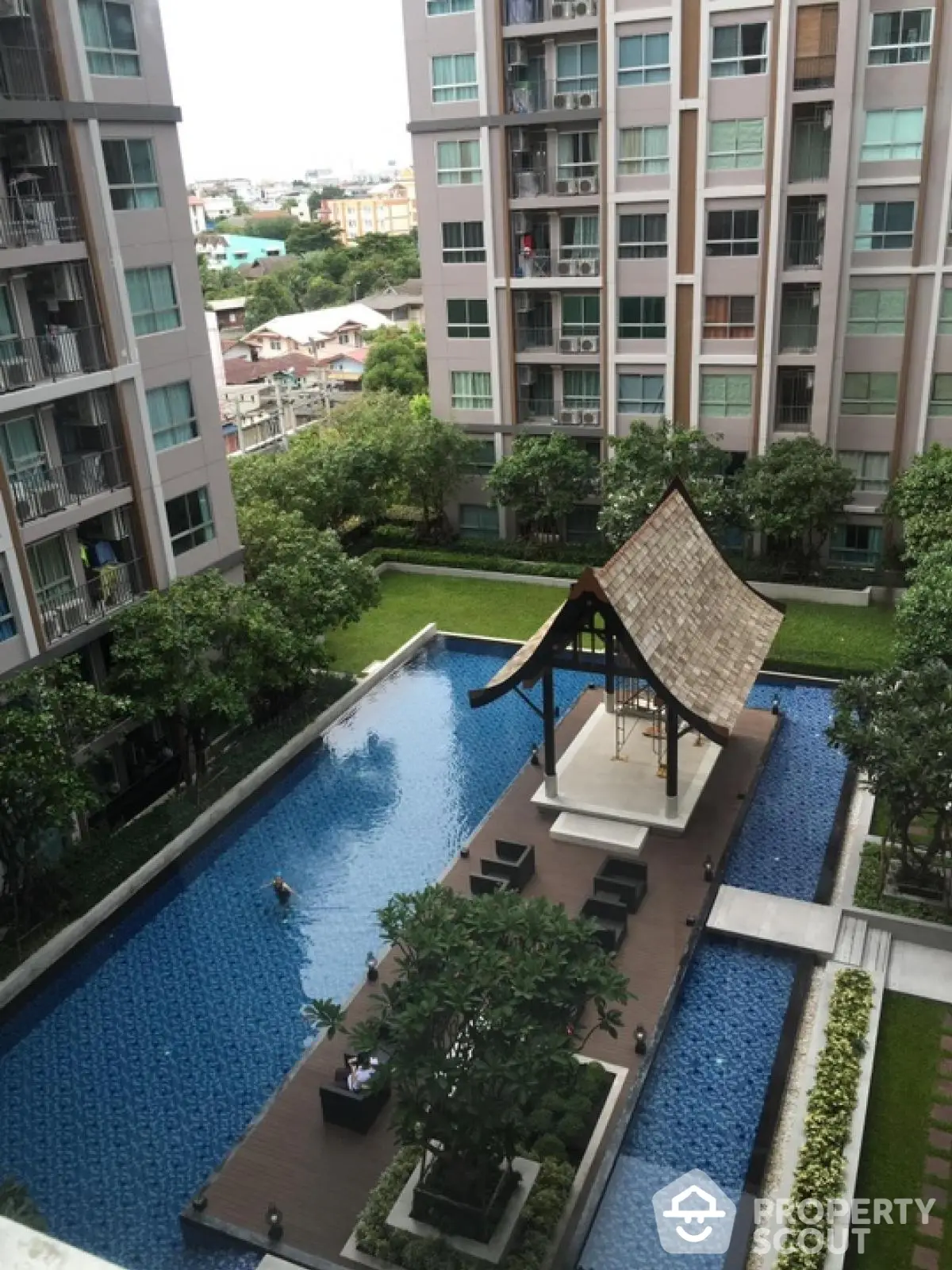 Luxurious condominium with serene pool and lush garden view