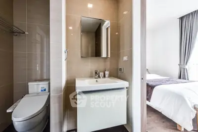 Modern bathroom with sleek design adjacent to a cozy bedroom