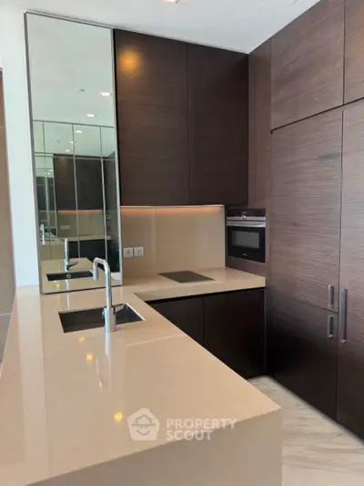 Modern kitchen with sleek dark wood cabinets and integrated appliances