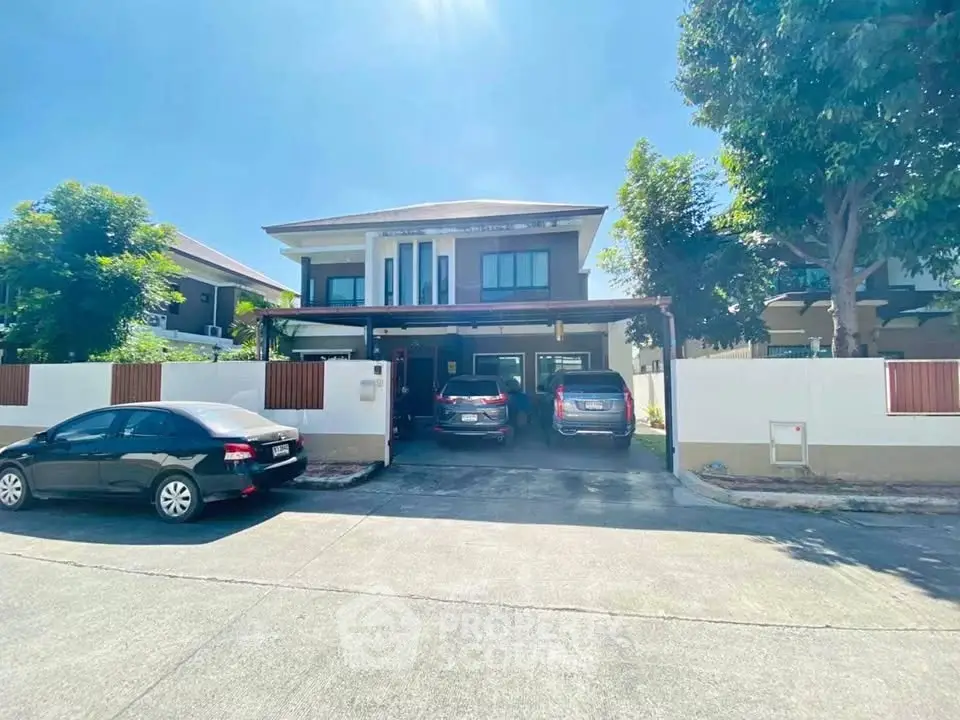 Spacious modern house with multiple car garage and lush greenery in a serene neighborhood.