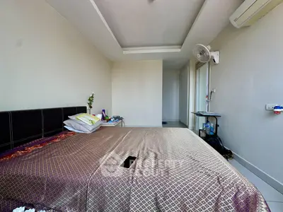 Spacious bedroom with modern decor and natural light, featuring a comfortable bed and air conditioning.