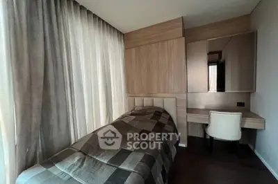 Cozy bedroom with modern design, featuring a single bed and stylish desk, perfect for a compact living space.