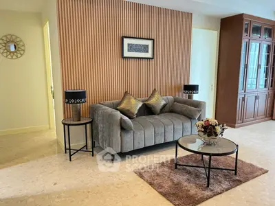 Stylish living room with plush gray sofa, elegant decor, and modern lighting.