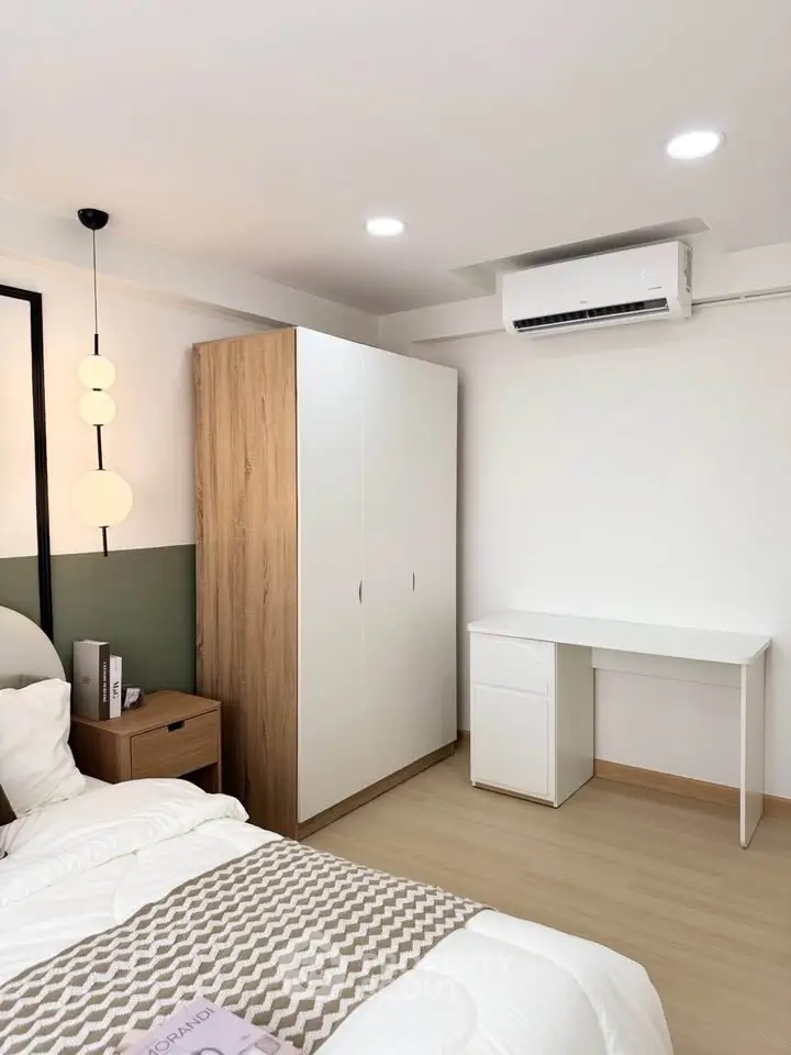 Modern bedroom with stylish decor, featuring a cozy bed, sleek wardrobe, and efficient air conditioning.