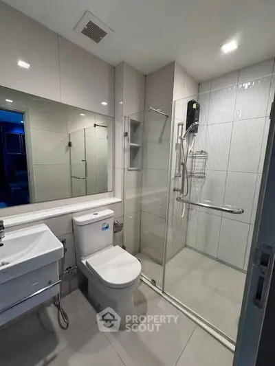 Modern bathroom with glass shower enclosure and sleek fixtures