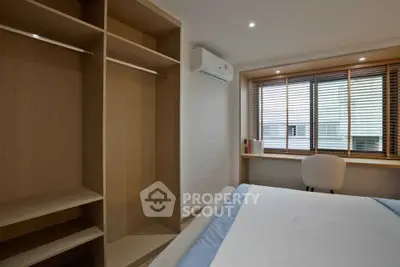 Modern bedroom with built-in wardrobe and large window for natural light.