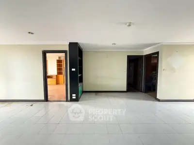Spacious open-plan living area with tiled flooring and ample natural light, perfect for modern living.