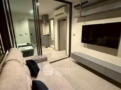 Modern living room with sleek design and wall-mounted TV in a stylish apartment.