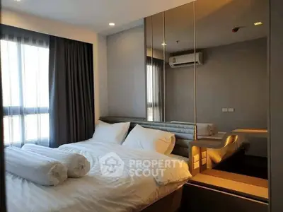 Modern bedroom with mirrored wall and cozy bedding in a stylish apartment.