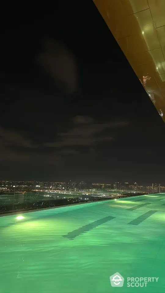 Stunning night view from rooftop with city skyline and illuminated pool