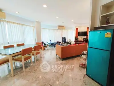 Spacious living room with dining area and modern appliances, perfect for family gatherings.