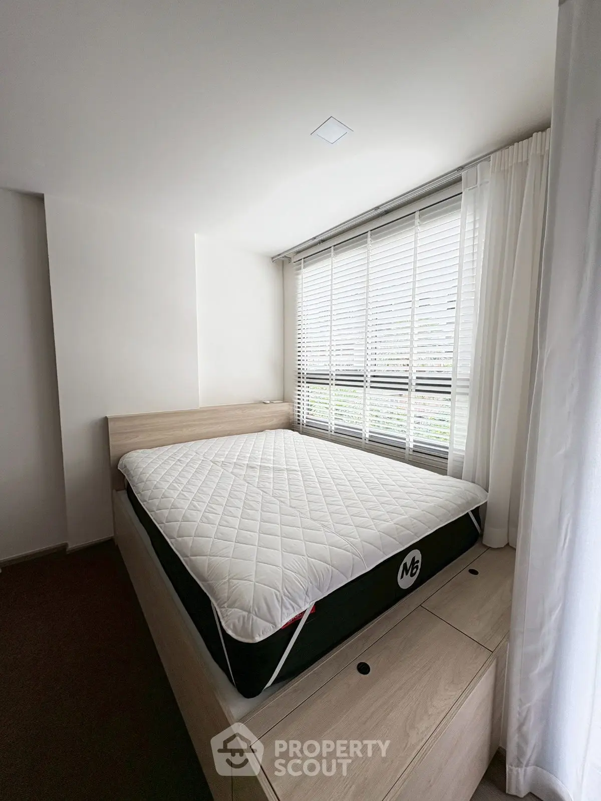 Modern bedroom with large window and stylish bed frame