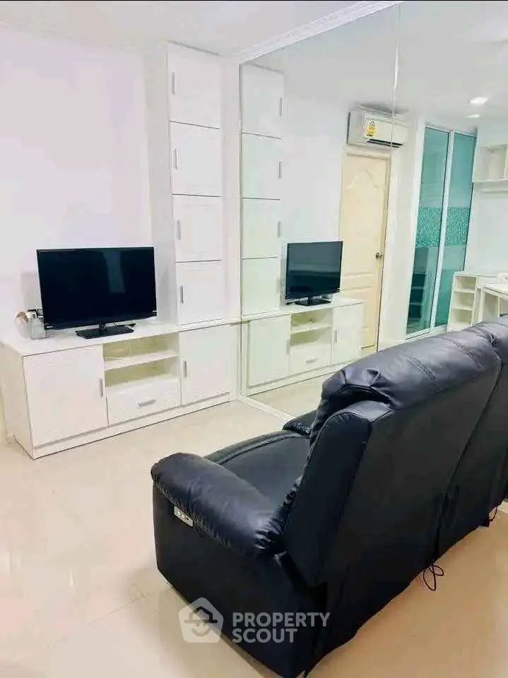 Modern living room with sleek black recliner and mirrored wall cabinets