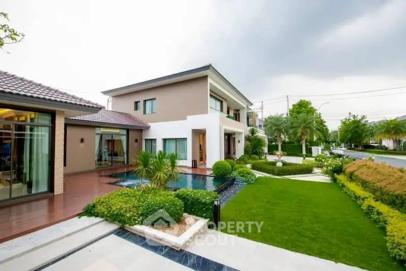 Luxurious modern house with lush garden and pool in serene neighborhood.