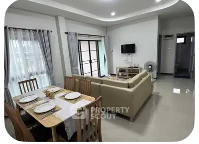 Spacious modern living room with dining area, featuring elegant decor and ample natural light.