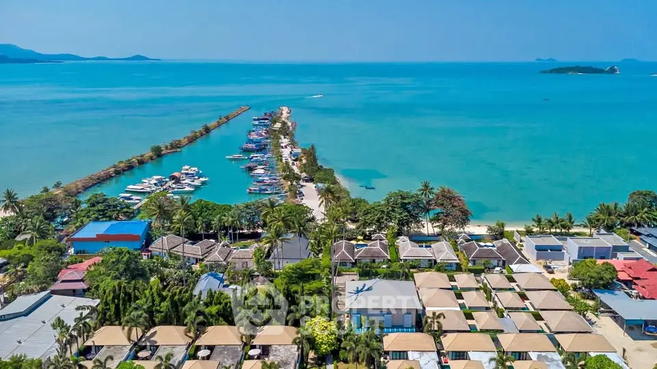Stunning aerial view of beachfront properties with turquoise ocean and marina