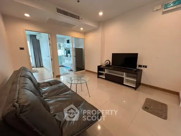 Modern living room with sleek furniture and TV setup in a stylish apartment.