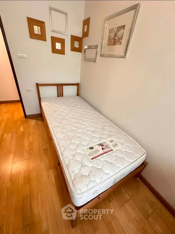 Cozy bedroom with single bed and stylish wall decor in modern apartment.