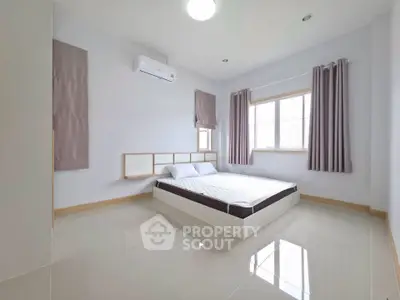 Spacious and bright bedroom with modern minimalist design and large window.