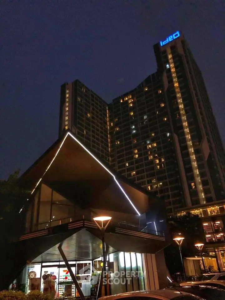 Modern high-rise building with illuminated facade and sleek design at night