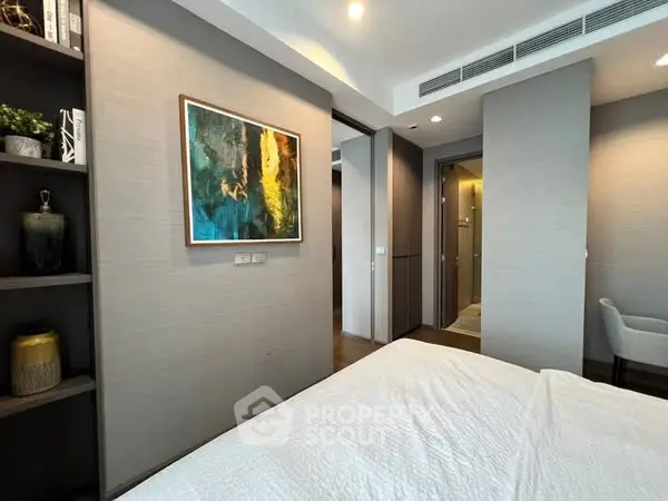 Modern bedroom with elegant decor and stylish artwork, featuring a cozy ambiance.