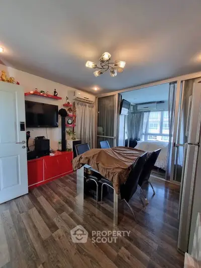 Modern living room with stylish decor and open layout, featuring a dining area and large windows.