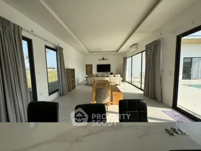 Spacious modern living room with abundant natural light, sleek furniture, and direct access to a sunny outdoor area, perfect for entertaining and relaxation.