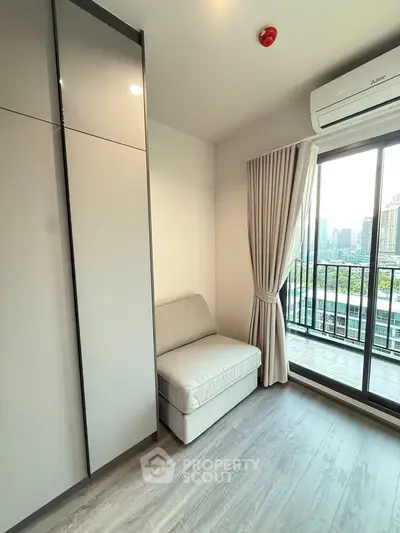 Modern apartment with sleek design, featuring a cozy seating area and balcony with city view.