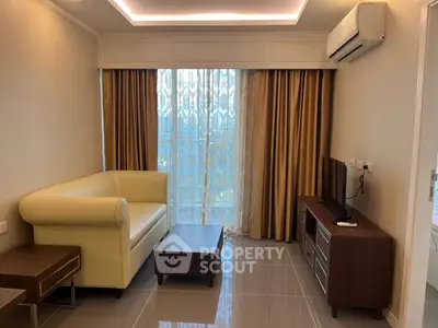 Modern living room with sleek furniture and large window, featuring a cozy sofa and wall-mounted air conditioner.