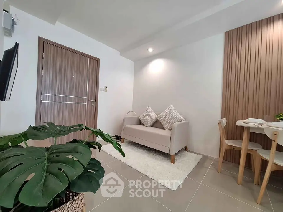 Modern living room with cozy sofa and dining area, featuring stylish decor and natural light.