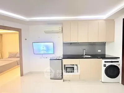 Modern studio apartment with sleek kitchen and integrated appliances