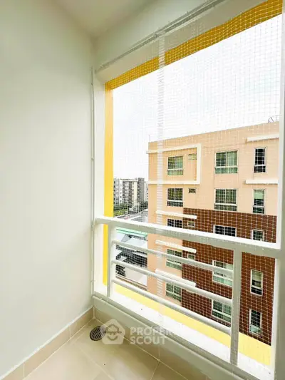 Charming balcony with safety netting and city view in modern apartment building.