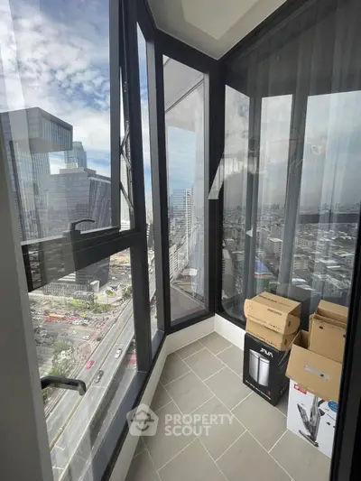 Stunning city view from modern high-rise balcony with floor-to-ceiling windows.