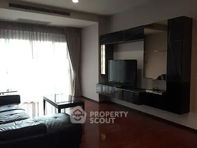 Modern living room with sleek black furniture and large window for natural light.
