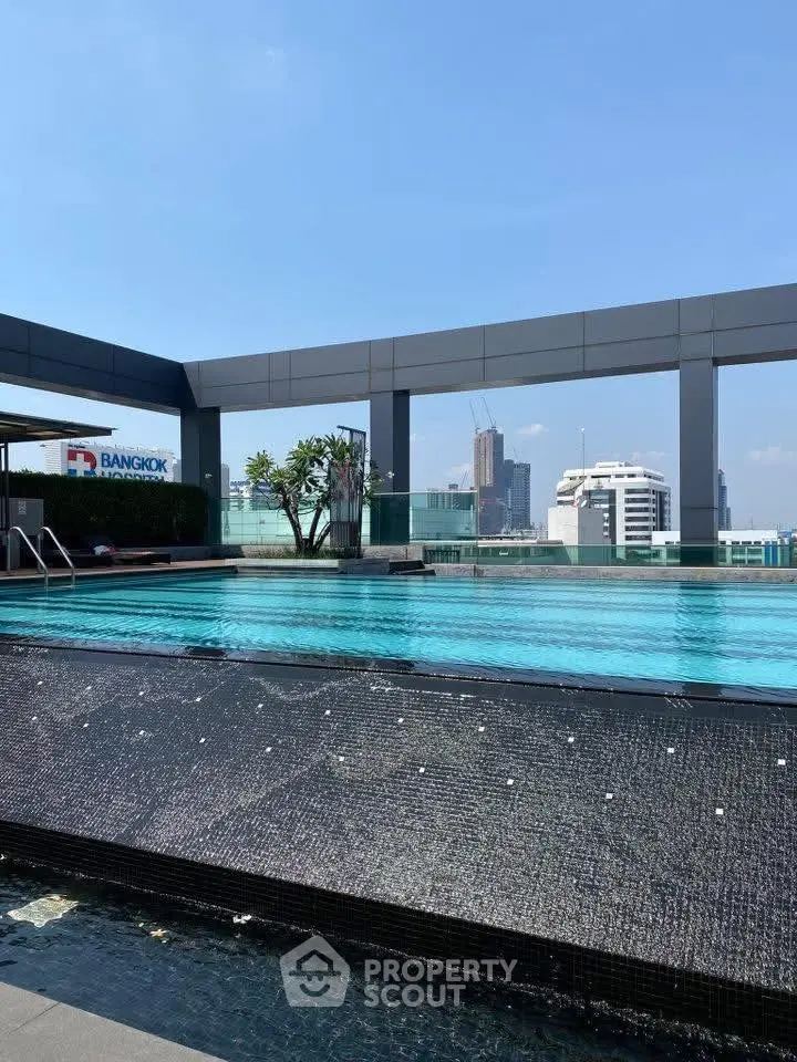 Luxurious rooftop pool with stunning city skyline views in Bangkok high-rise.