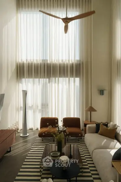 Luxurious living room with high ceilings, modern furniture, and elegant decor.