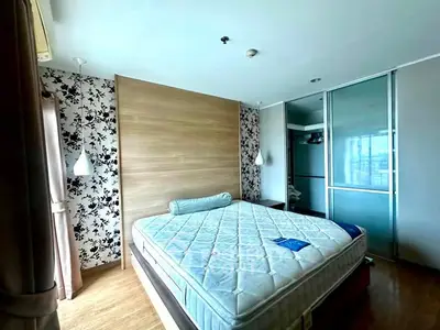 Spacious bedroom with modern decor and large window offering natural light.