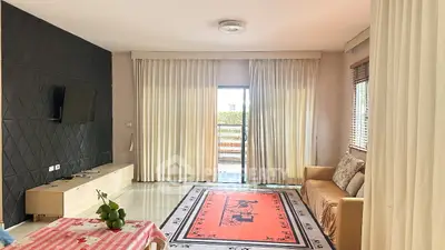 Spacious living room with modern decor and large window opening to a balcony.